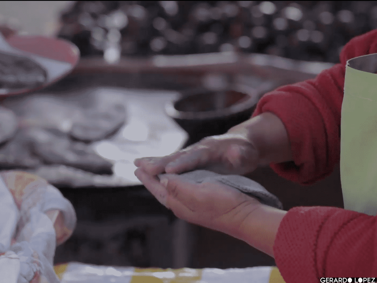 Woman makes corn tortillas by hand and cooks them on a large clay